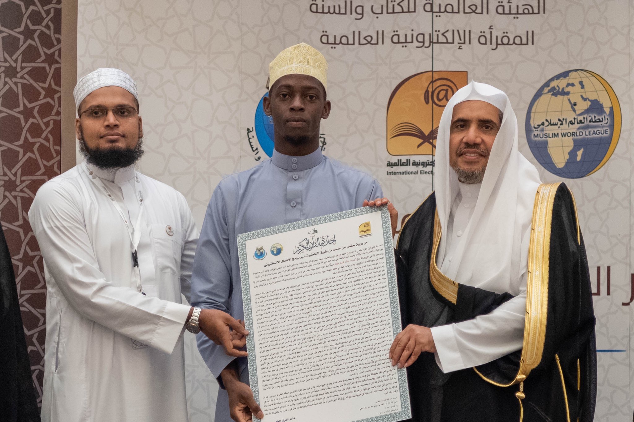 معالي الشيخ د.⁧محمد العيسى⁩، يسلم الشهادات القرآنية للمجازين بالسند المتصل لنبينا الكريم صلى الله عليه وسلم، عبر المقرأة الإلكترونية من 10 دول حول العالم
